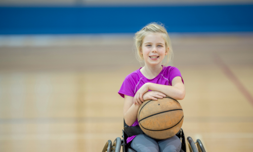 Een meisje amuseert zich bij haar hobby rolstoelbasketbal.